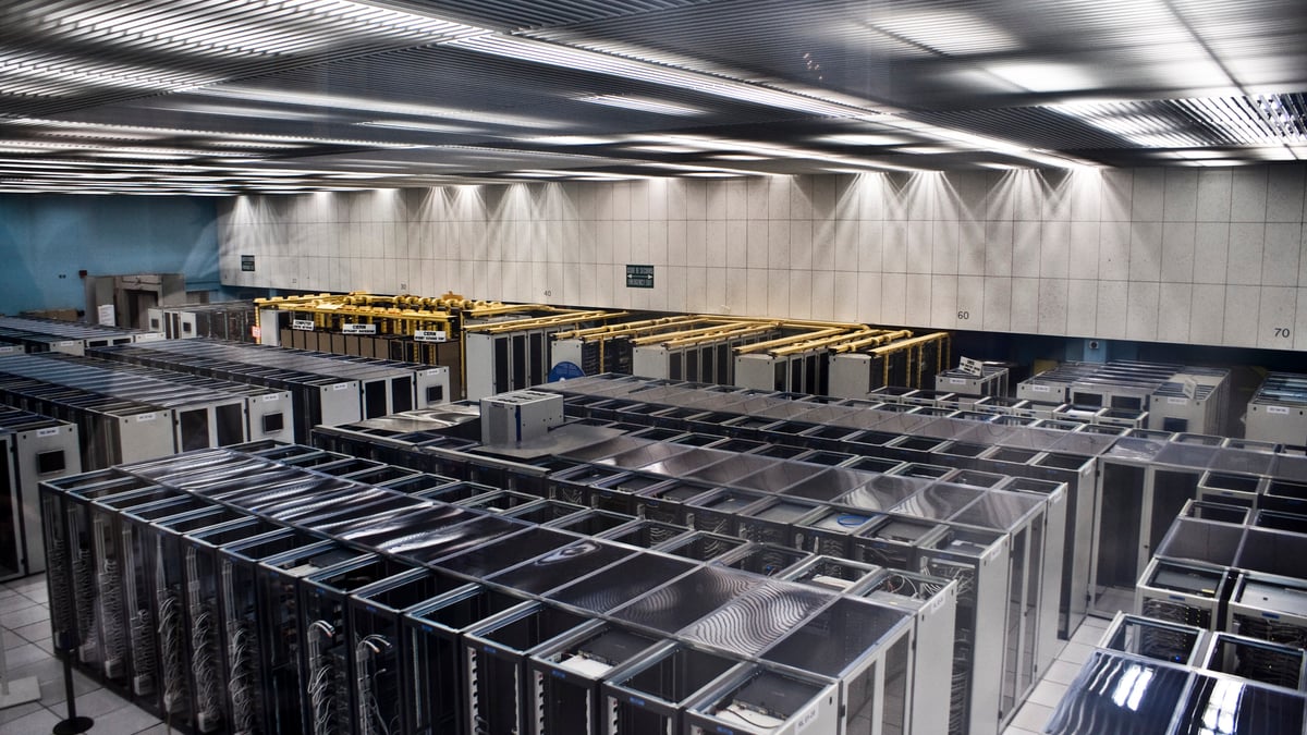 Långa rader av serverskåp i en stor datorhall.