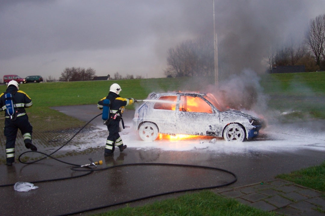 Brandmän släcker en bilbrand med brandsläckningsskum.