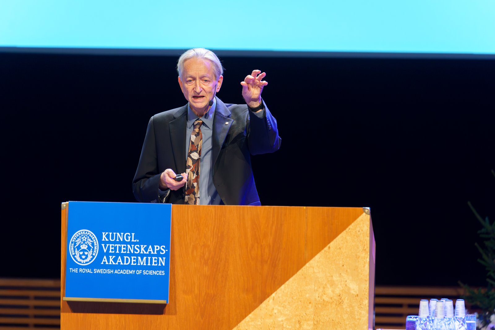 Geoffrey Hinton föreläser vid ett podium under Nobelveckan 2024.