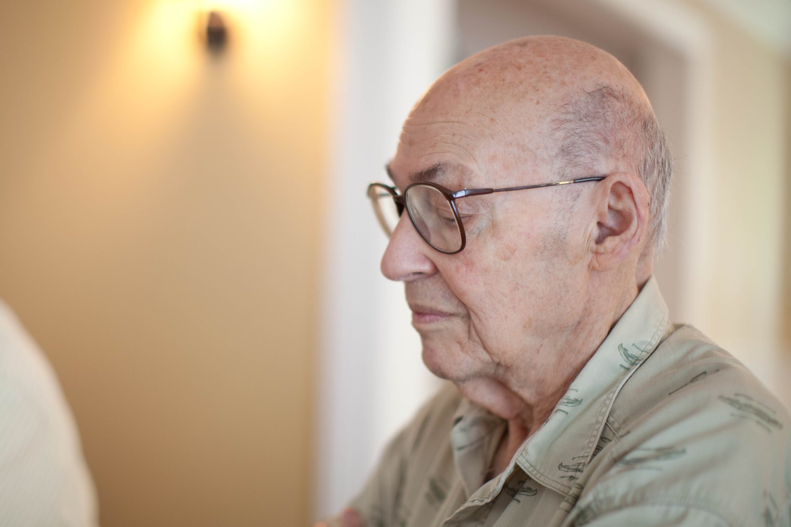 Marvin Minsky sitter framför en mörk vägg och tittar mot kameran.