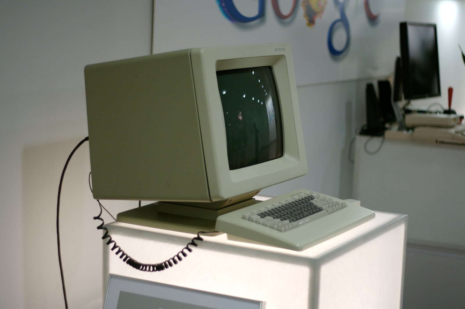 En beige Symbolics LISP-dator med bildskärm och tangentbord står på ett museum.